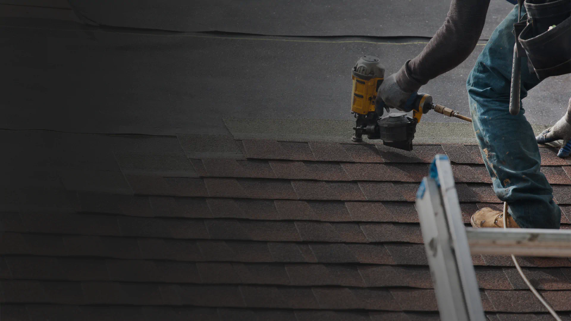 close up shot of worker installing new apshalt roof shingles